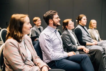 Meetings in Leipzig | Leipzig Convention Bureau People seated in a row in a meeting room – presented by Leipzig Convention Bureau