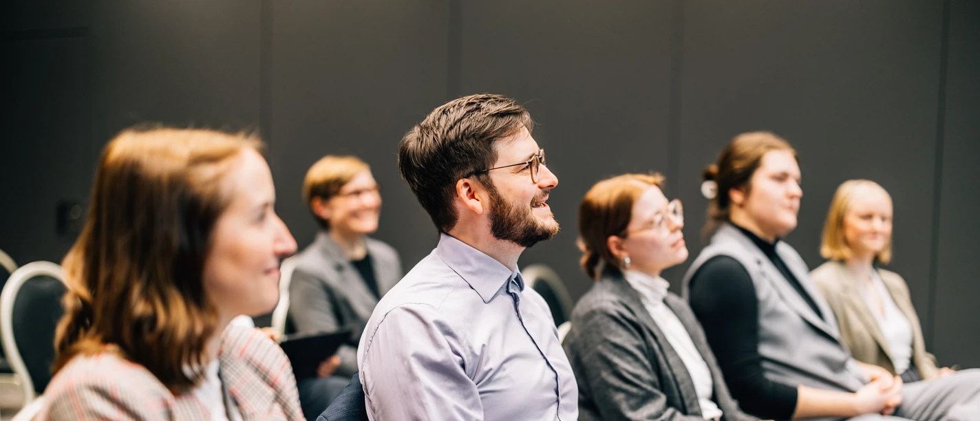 Tagen in Leipzig | Leipzig Convention Bureau Personen sitzen in einer Reihe in einem Tagungsraum – präsentiert vom Leipzig Convention Bureau