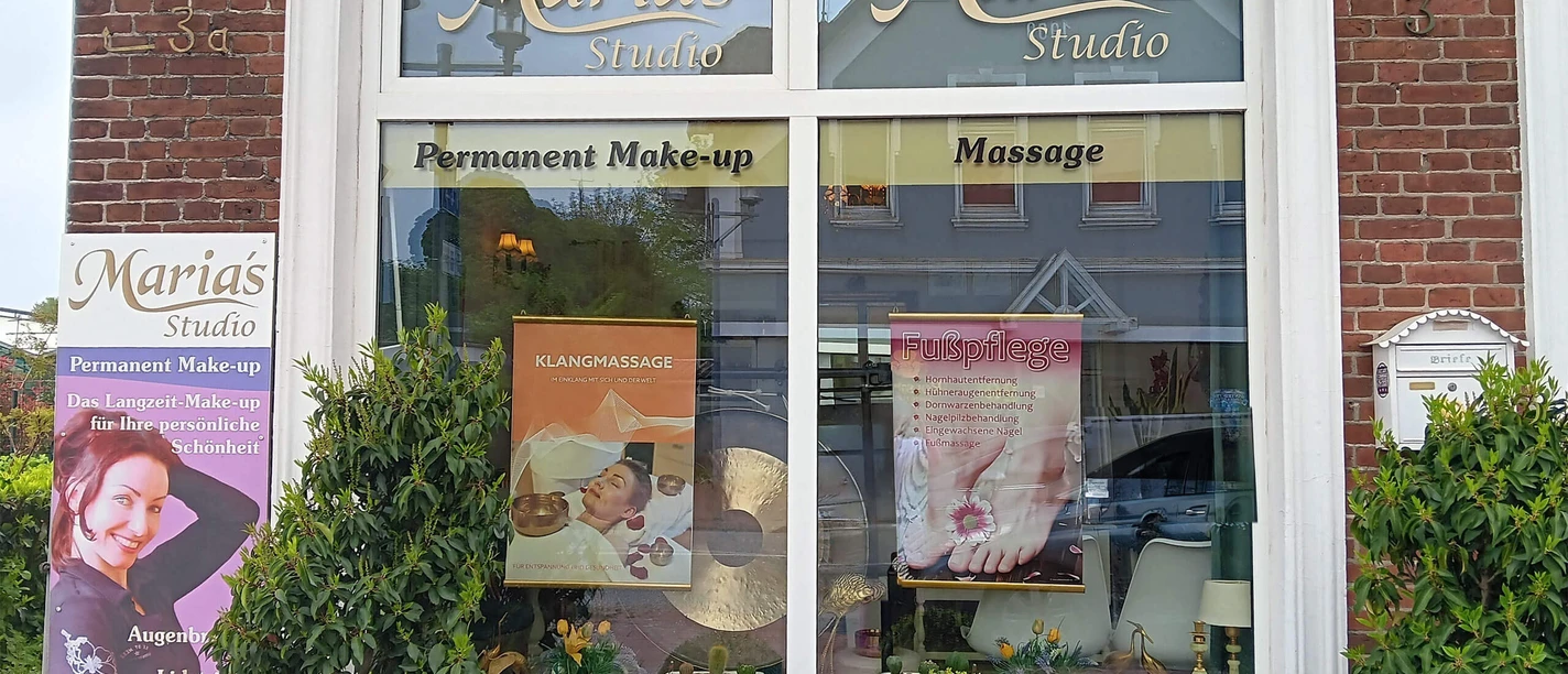 Marias-Studio-Aussenansicht.jpg Backsteinfassade von Marias Studio. Die Schaufenster bewerben Massage und Permanent Make-up.