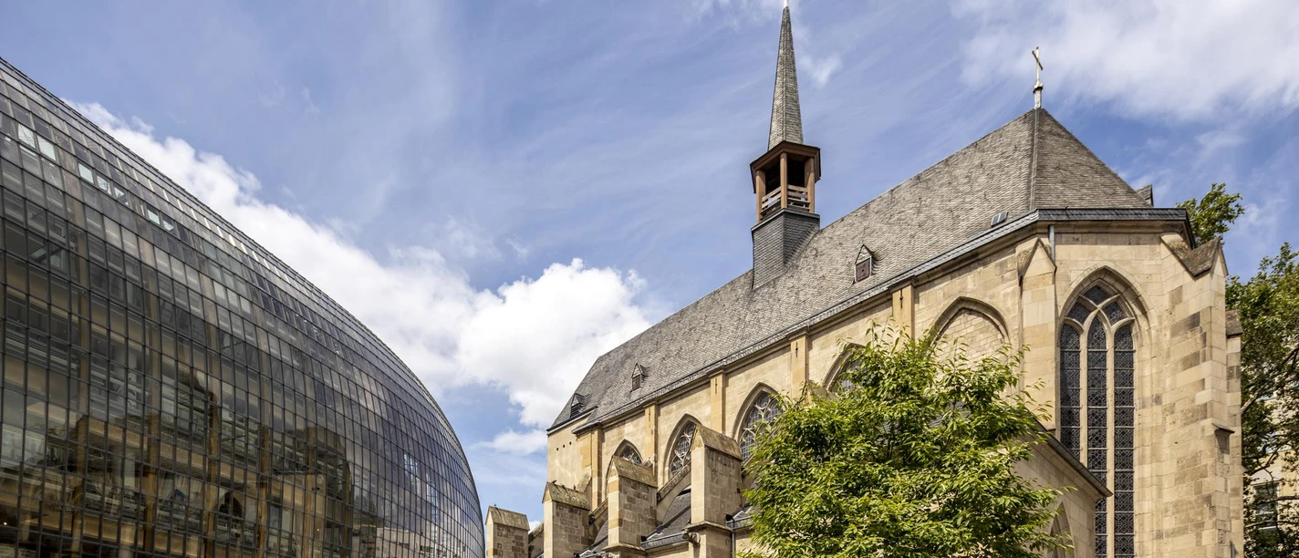 Antonite Church Gothic church next to modern glass building under a blue sky with light clouds