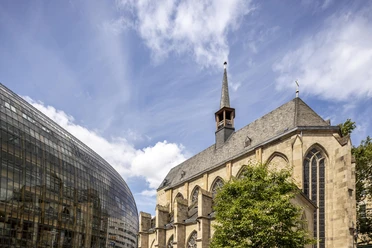 Antoniterkirche Gotische Kirche neben modernem Glasbau unter blauem Himmel mit leichten Wolken