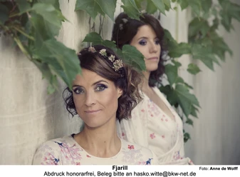 FJARILL_Midsommar_Foto_1_von_Anne_de_Wolf.jpg Die zwei Musikerinnen von Fjarill an einer begrünten Wand, eine trägt Blumen im Haar.