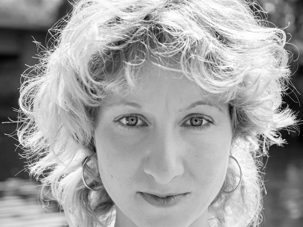 Ann Esswein Portrait of a young person with curly hair and a calm look in black and white.