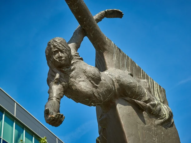 Stadtansichten von Bremerhaven Bronzefigur einer Frau am Brunnen Bugwelle, die mit ausgestrecktem Arm aus einem Bug ragt.