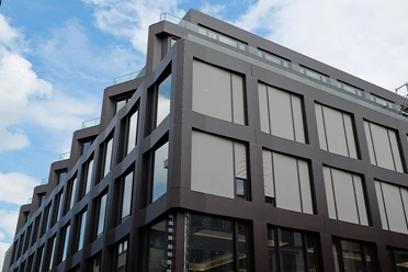 Interim of the Cologne City Library Modern building with a dark façade and large windows under a blue sky