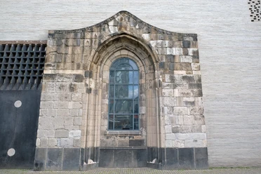 Madonna in den Trümmern Gotische Steinwand mit großem Fenster und Statue hinter Glas