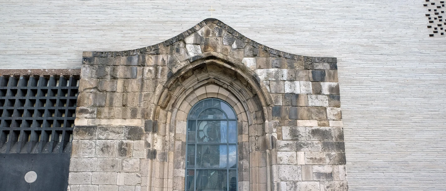 Madonna in den Trümmern Gotische Steinwand mit großem Fenster und Statue hinter Glas
