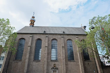 St. Maria in der Kupfergasse Backsteinfront mit hohen Spitzbogenfenstern und kleinem Turm zwischen Bäumen