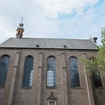 St. Maria in the Kupfergasse Brick front with high pointed arch windows and small tower between trees