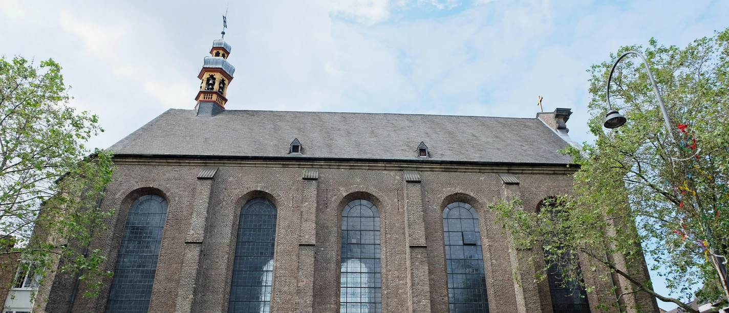 St. Maria in the Kupfergasse Brick front with high pointed arch windows and small tower between trees