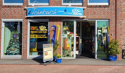 Fehnbuch - Eingang - neues Foto von 2026.jpg Eingang der Buchhandlung Fehnbuch in einem Backsteingebäude mit großen Schaufenstern.