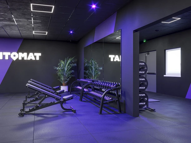 FITOMAT Otterndorf Kurzhantel Einladender Freihantelbereich mit Hantelbank im modernen, violetten FITOMAT-Studio.