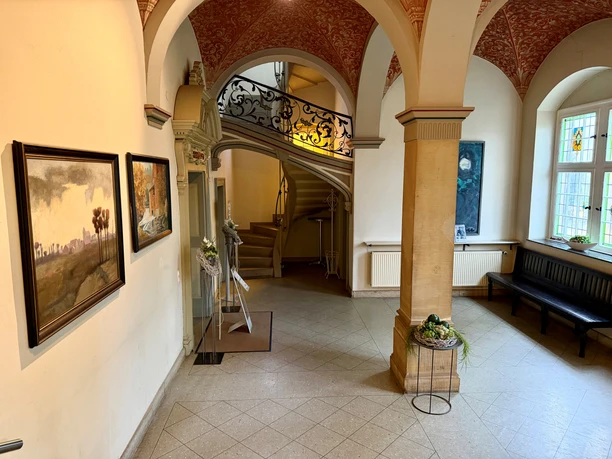 Altes Amtsgericht Petershagen (15).jpg Historischer Flur mit bemalter Gewölbedecke, Wandgemälden und geschwungener Steintreppe.