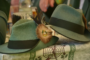 Schützenfest Zwei grüne Schützenhüte mit Federschmuck auf einem Tisch beim lebhaften Otterndorfer Fest.