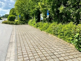 Wohnmobilstellplatz Am Cronsbach, Steinhagen - Stellplatz (C) Gemeinde Steinhagen.jpg Befestigter Wohnmobilstellplatz mit zwei Parkflächen am Straßenrand, umgeben von Bäumen und Hecken
