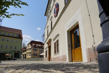 Stadtinformation Sondershausen - Außenansicht Außenansicht der Stadtinformation Sondershausen mit Eingangstür an einem gepflasterten Platz.