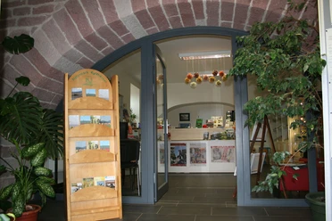 Bürger- und Gästeservice Stadt Kelbra Eingang der Tourist-Information Kelbra im Steingewölbe mit Prospektständer und Infotresen.