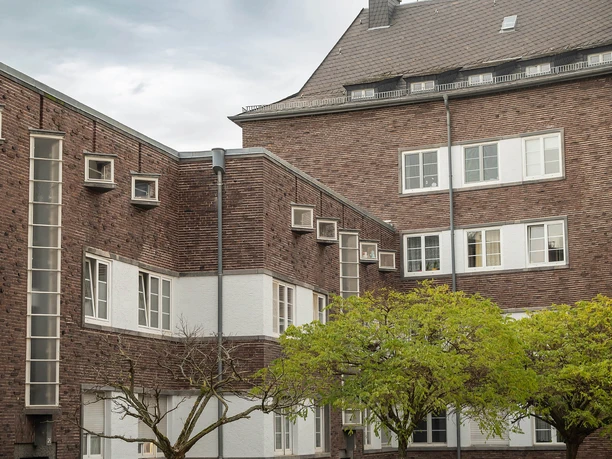 Frankfurt - Wohngebäude Kranichsteiner Straße Backsteinfassade mit Fenstern und Bäumen