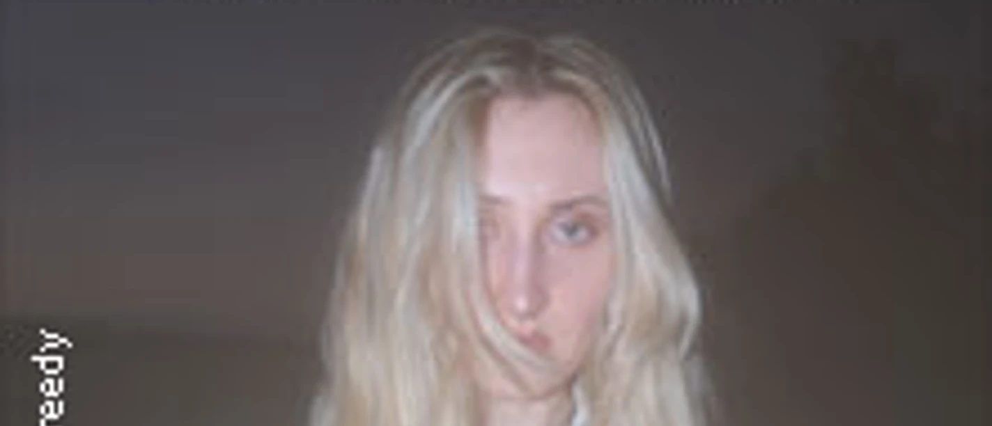 Eine blonde Person vor dunklem Hintergrund mit hellem Schimmer und dem Schriftzug NOTHHING SPECIAL.