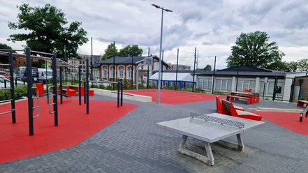 Trainieren auf der Allerinsel Outdoor-Sportplatz mit Tischtennisplatte, Fitnessgeräten und rotem Basketballfeld.
