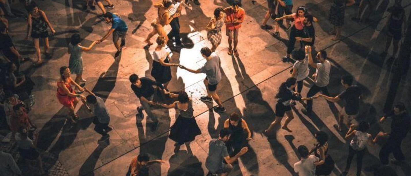 Salsa-Party (c) Franz.jpg In einem Veranstaltungssaal tanzen viele Menschen Salsa auf Holzparkett.