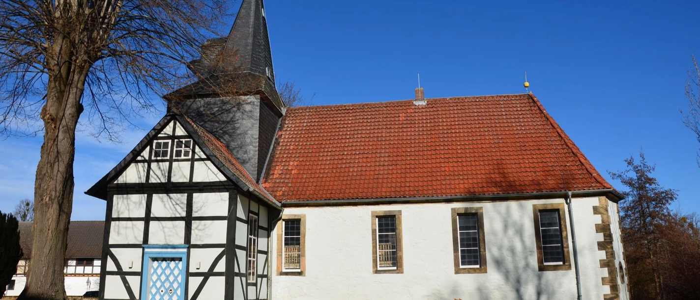 Kirche_Flachstöckheim_HD_16zu9.JPG Dorfkirche mit weißer Fassade, rotem Dach, markantem Fachwerk, blauer Tür und spitzem Kirchturm.