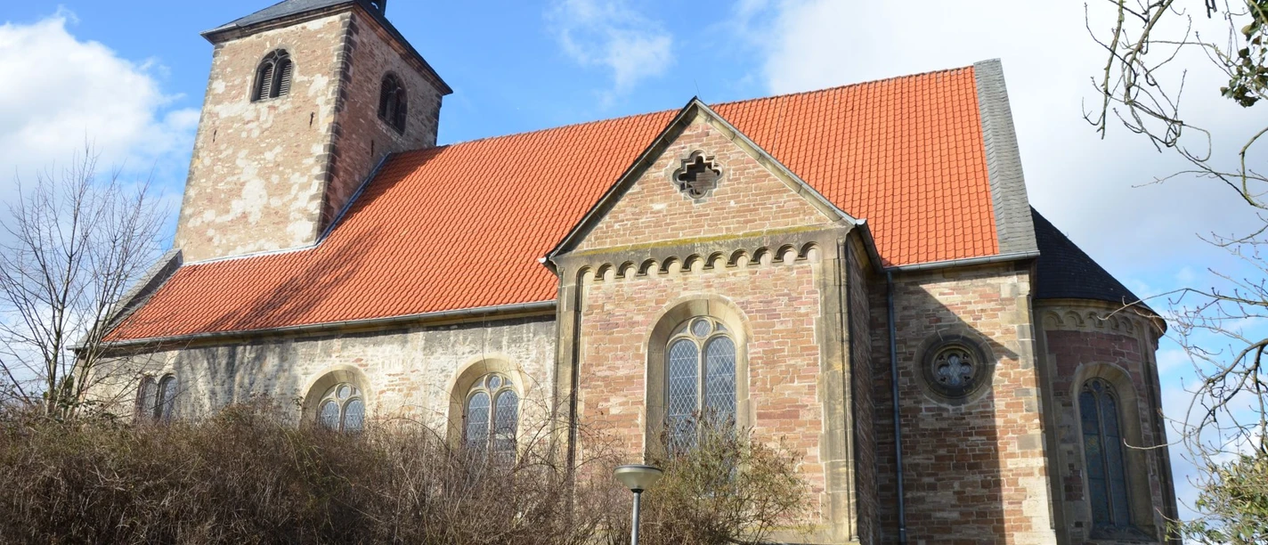 St.Nicolai_Gebhardshagen_HD_16zu9.JPG Steinkirche St. Nicolai in Gebhardshagen mit rotem Ziegeldach und Turm vor blauem Himmel.