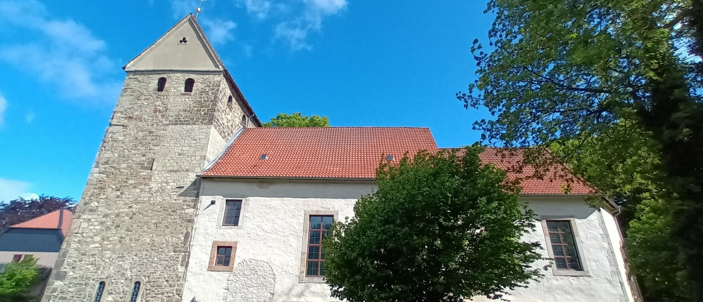 Barum_Kirche_HD_16zu9.jpg Kirche St. Nikolai in Barum mit markantem Steinturm, weißem Schiff und rotem Dach im Grünen.
