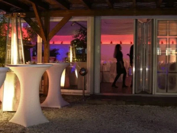 Location Titelbild Außenbereich der Eventlocation Tafelfreuden mit Stehtischen und beleuchtetem Innenraum