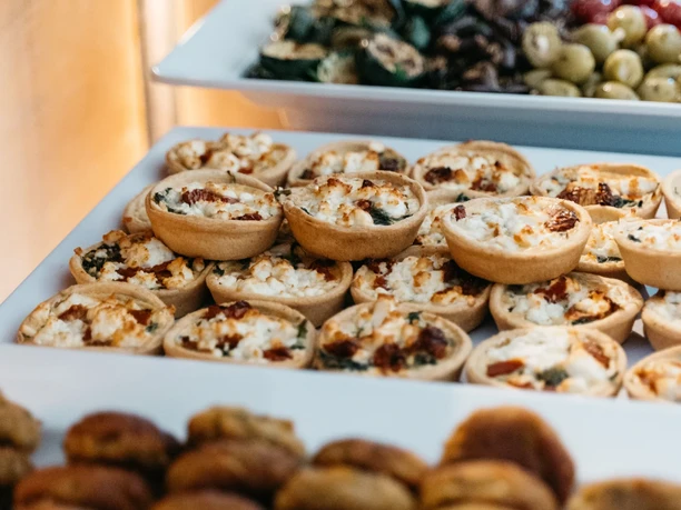 Savory mini quiches with cheese and vegetables at a catering buffet