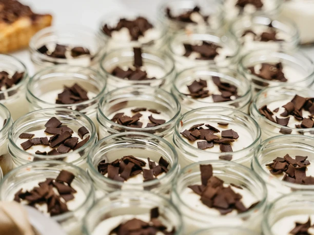 Tafelfreuden Desserts im Glas mit heller Creme und dunklen Schokoraspeln für ein Catering