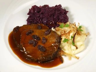 Aachener Brauhaus Degraa Auf einem Teller ist Sauerbraten mit Rosinen, Kartoffelpürree und Rotkohl angerichtet