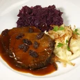 Aachener Brauhaus Degraa Auf einem Teller ist Sauerbraten mit Rosinen, Kartoffelpürree und Rotkohl angerichtet