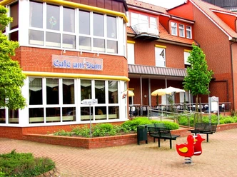 Cafe_am_Dom_Haren.jpg Backsteincafé mit Terrasse, Sonnenschirmen und barrierefreiem Zugang am Martinusplatz in Haren.