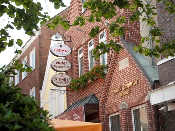 Hotel Schmidt am Markt Backsteinfassade des Hotel-Restaurants Schmidt am Markt in Meppen mit schmiedeeisernem Firmenschild.