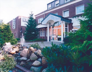 H_Hubertushof_Lingen_mini.jpg Backsteingebäude des Hotels Hubertushof in Lingen mit Glasportal, Vorgarten und kleinem Springbrunnen