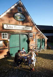 Altes Gasthaus Giese Vier Personen sitzen im Hof vor dem Backsteinhaus Altes Gasthaus Giese und essen gemeinsam.
