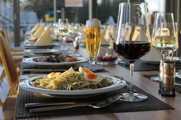 Impressionen ein gedeckter Tisch mit 2 Gerichten, sowie ein Glas Bier, ein Glas Rotwein und ein Glas Weißwein