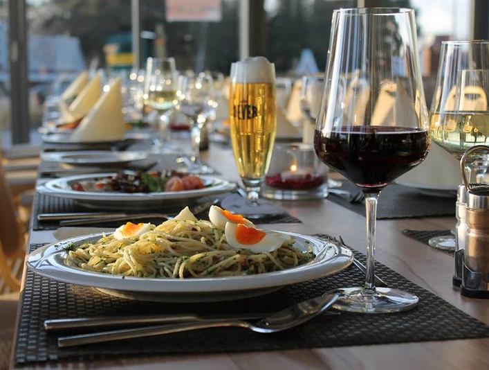 Impressionen ein gedeckter Tisch mit 2 Gerichten, sowie ein Glas Bier, ein Glas Rotwein und ein Glas Weißwein
