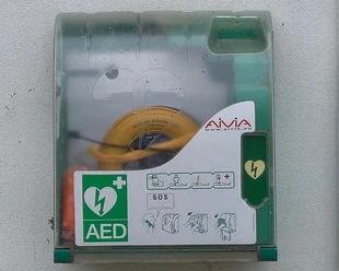 Defibrillator Insel Wilhelmstein Ein Defibrillator hängt in einem grünen Kasten mit durchsichtigem Plastik an der Hauswand auf der Insel Wilhelmstein