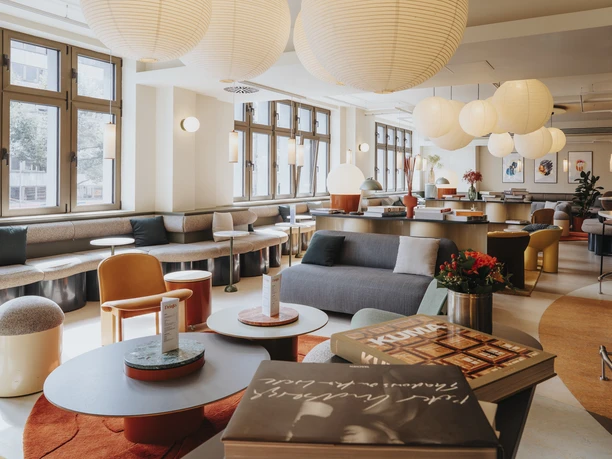 Lounge Moderne Lounge mit Sitzinseln, runden Tischen, großen Papierlampen und breiten Fenstern