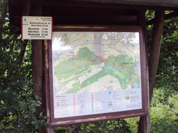 Hölzerne Wandertafel im Grünen mit Karte für den Rundweg 30 Hohe Warte.