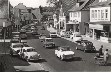 Peterstraße 1960er Jahre_Gemeindearchiv Historische Aufnahme der Peterstraße in den 1960er Jahren mit regem Autoverkehr und Passanten.
