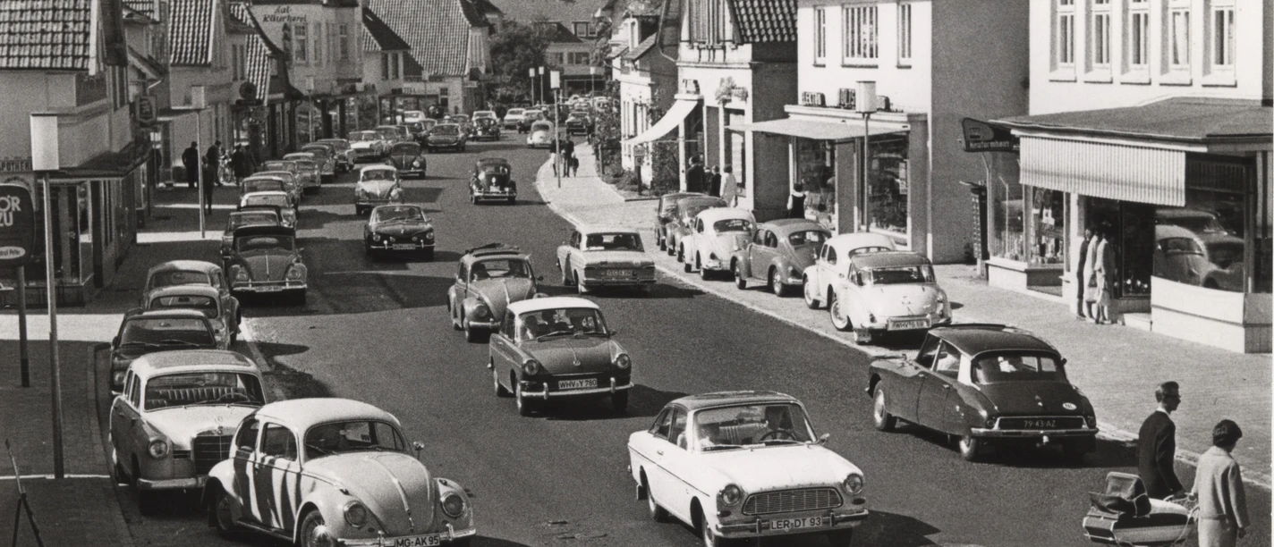 Peterstraße 1960er Jahre_Gemeindearchiv Historische Aufnahme der Peterstraße in den 1960er Jahren mit regem Autoverkehr und Passanten.