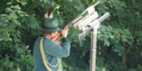 Schützenfeste Schütze in grüner Uniform zielt mit Gewehr am Schießstand im Freien