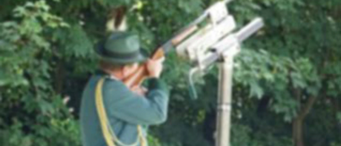 Schützenfeste Schütze in grüner Uniform zielt mit Gewehr am Schießstand im Freien
