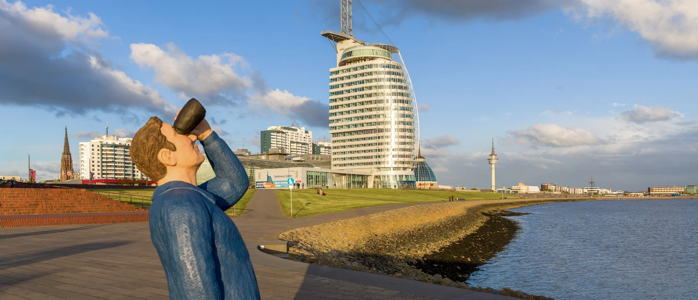 S8367-Bearbeitet (c) Helmut Gross_Erlebnis Bremerhaven_WEB.jpg Fernglasmann-Skulptur an der Weserpromenade vor dem Atlantic Hotel Sail City in Bremerhaven.