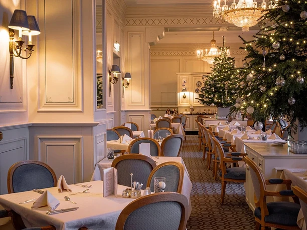 Advents- und Weihnachtsbrunch Festlich geschmückter Speiseraum mit gedeckten Tischen und beleuchtetem Weihnachtsbaum