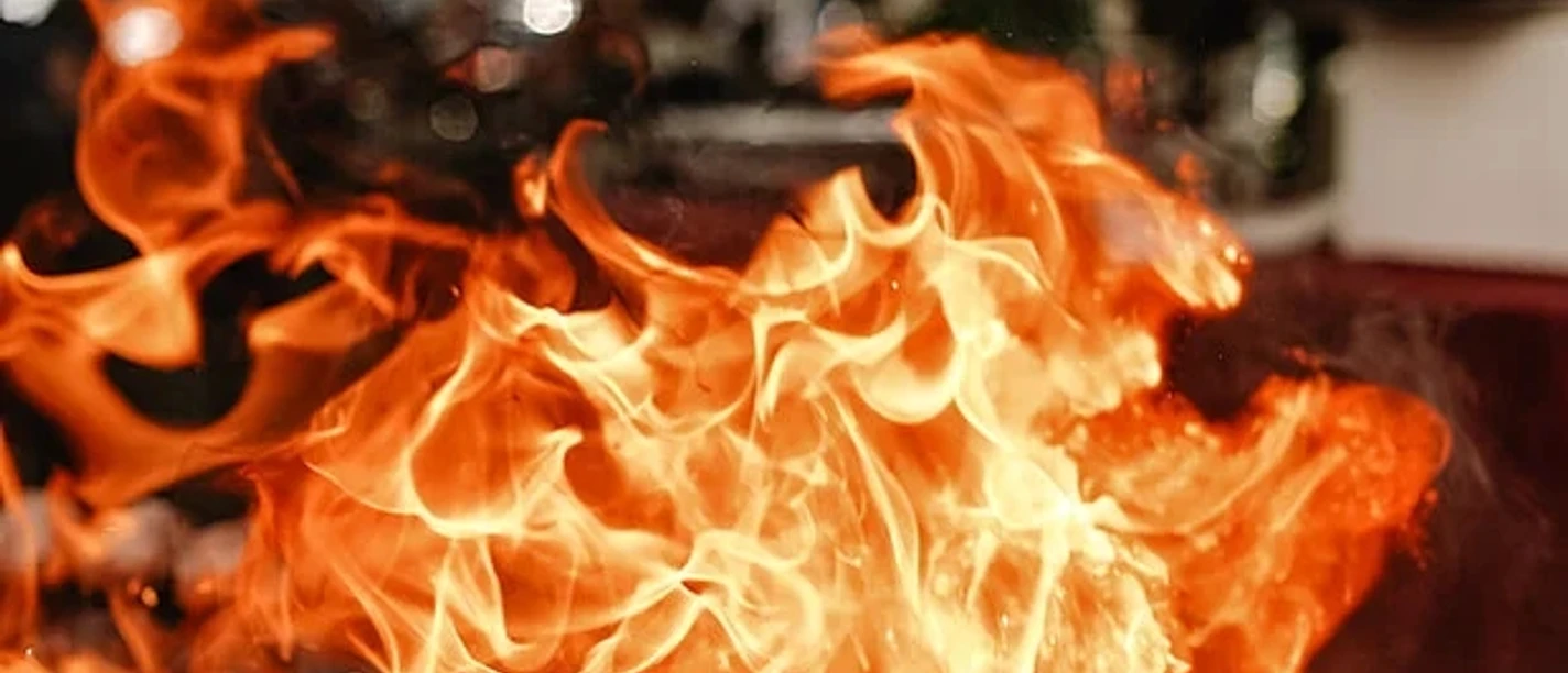 Bella BBQ Lodernde orange Flammen über einem Grill bei einer Outdoor‑Kochszene