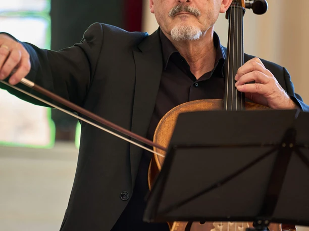 Kurkonzert-Spiegelsaal-Bad-Zwischenahn3.jpg Ein älterer Musiker mit Brille und grauem Bart spielt konzentriert Cello.